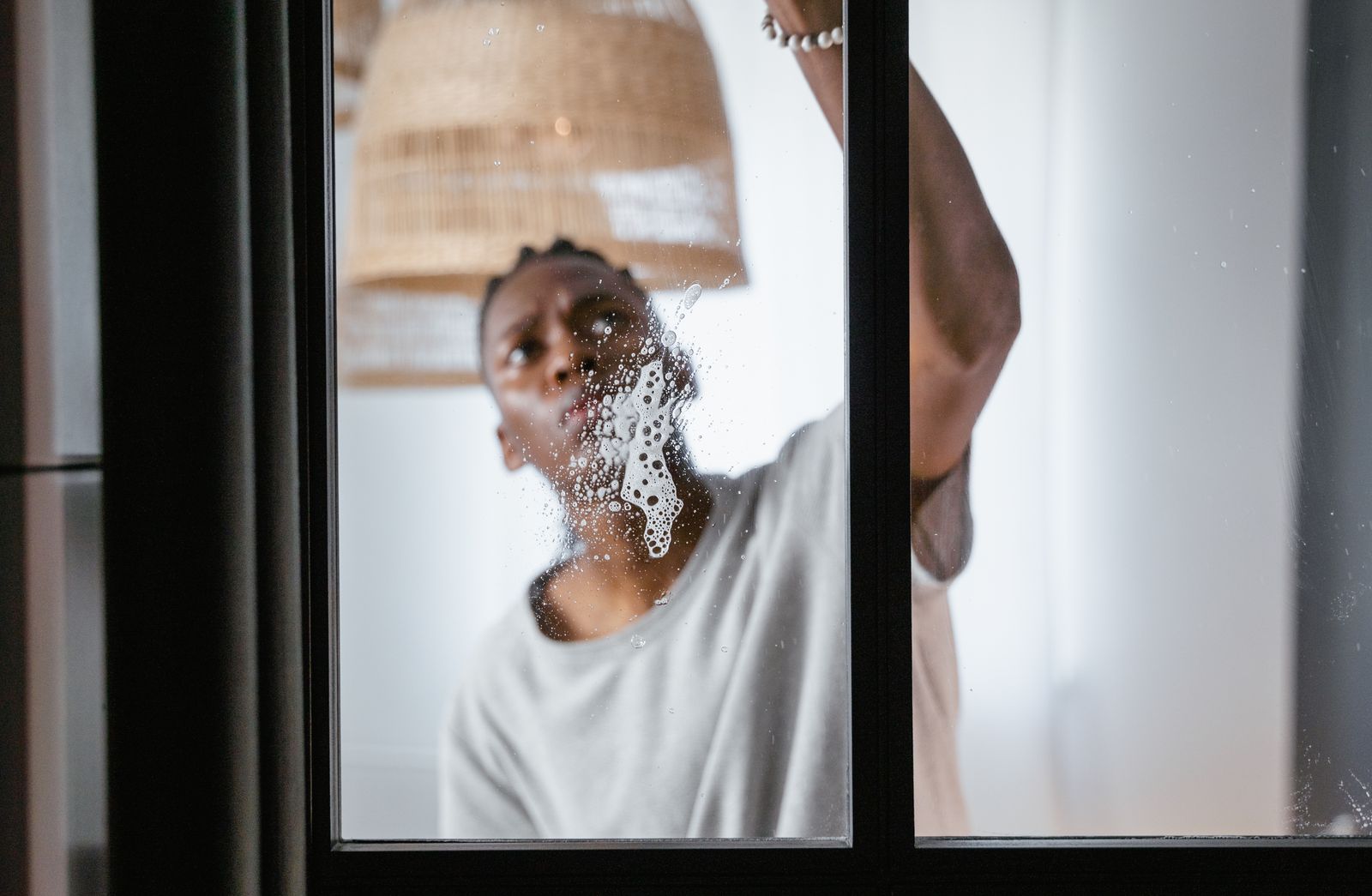 Technician cleaning and checking a window during a scheduled service visit